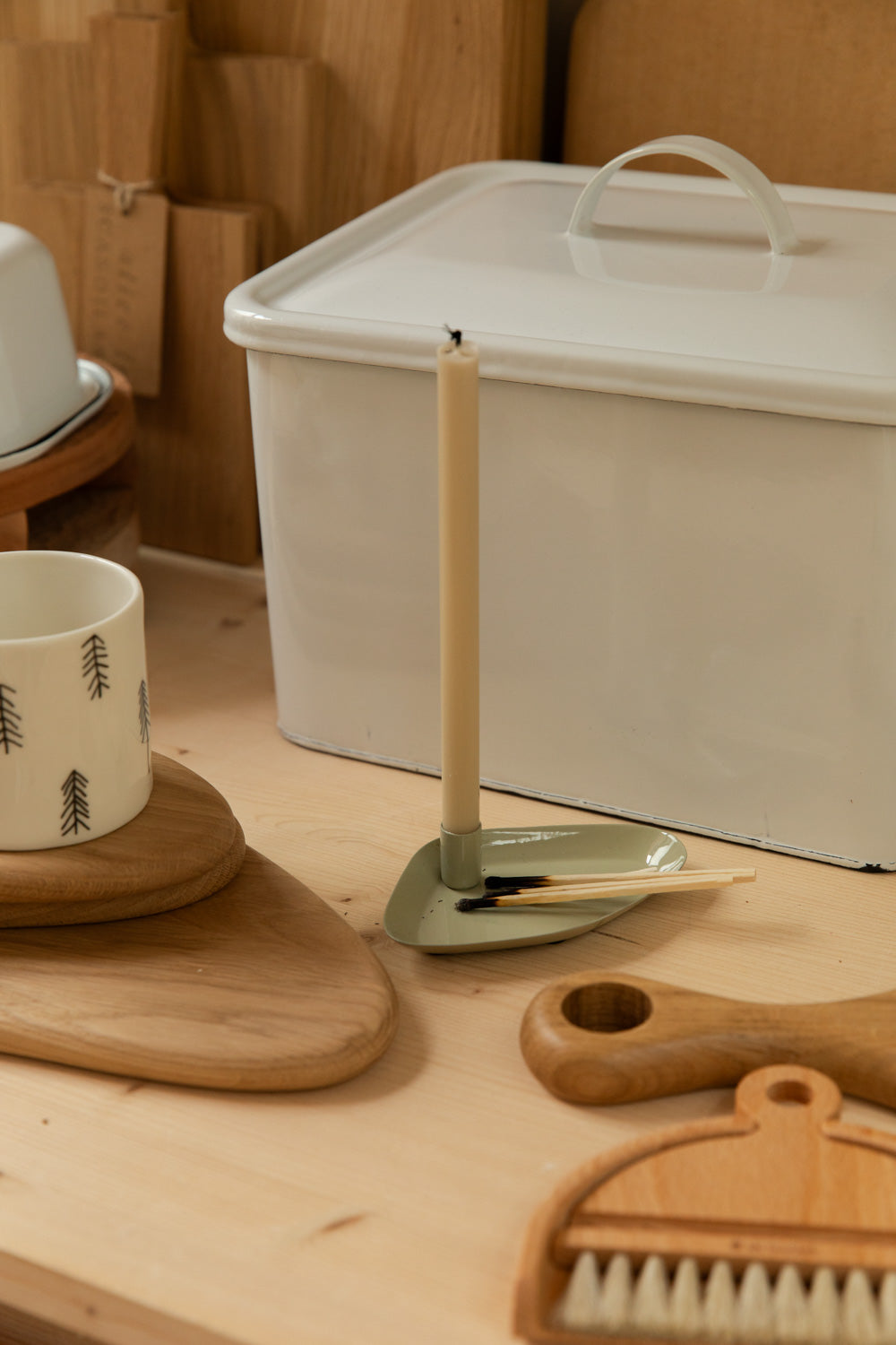 Wooden brush, candle holder, and other kitchen items on a wooden surface