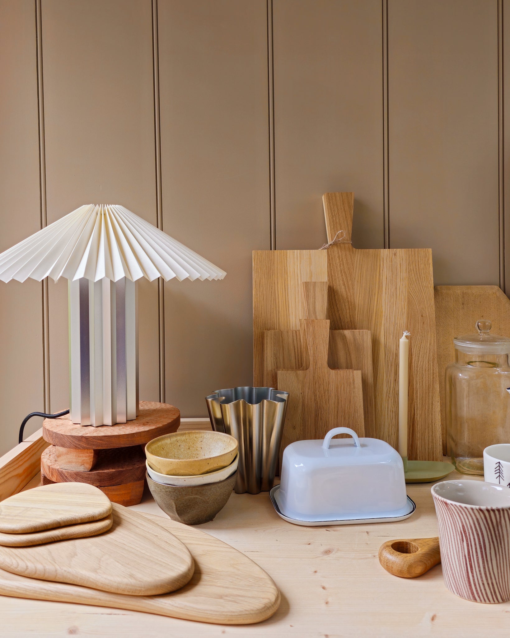 Collection of wooden chopping boards and Blomus Taite lamp in lily white in a kitchen setting.
