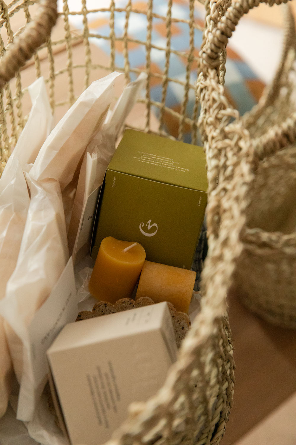 Woven market basket filled with a Cedar Rove candle box, beeswax pillar candles and tissue