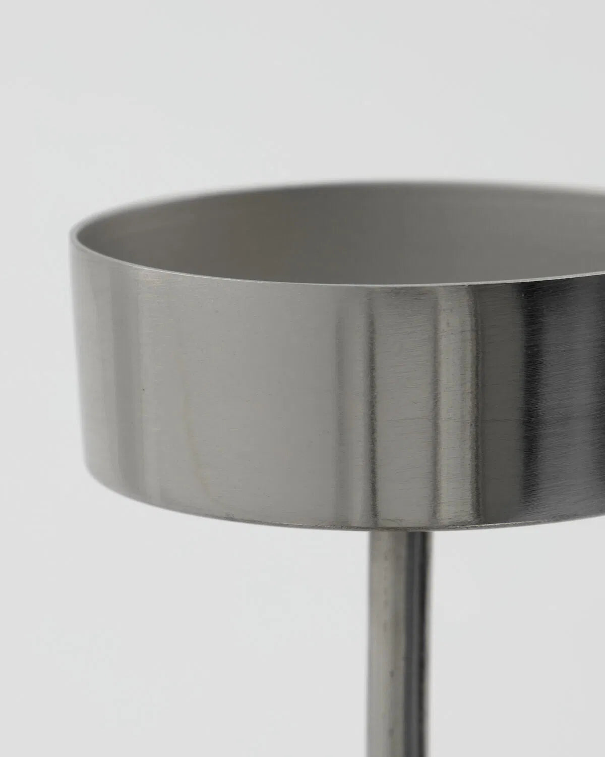 A close up of the top of a silver Anit tealight holder, against a white background.