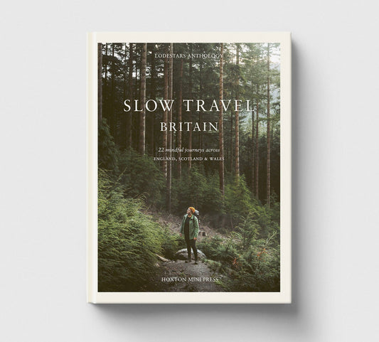 Book cover of 'Slow Travel Britain' with a person walking through a forest.