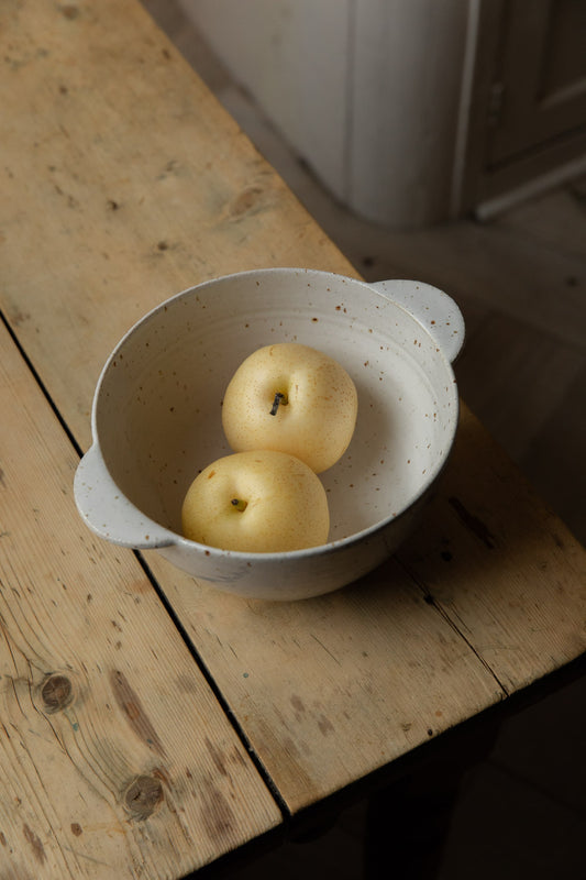 White speckle stoneware berry bowl holding two golden pears