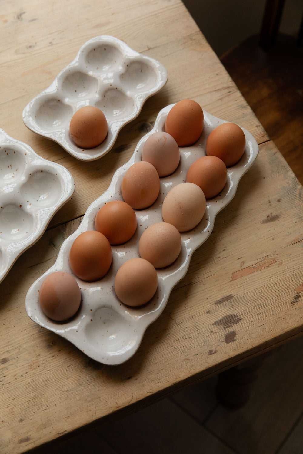 Close-up of a speckled stoneware egg tray holding brown hens' eggs