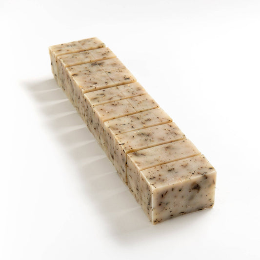 Block of tea tree and nettle soap cut into smaller pieces on a white background