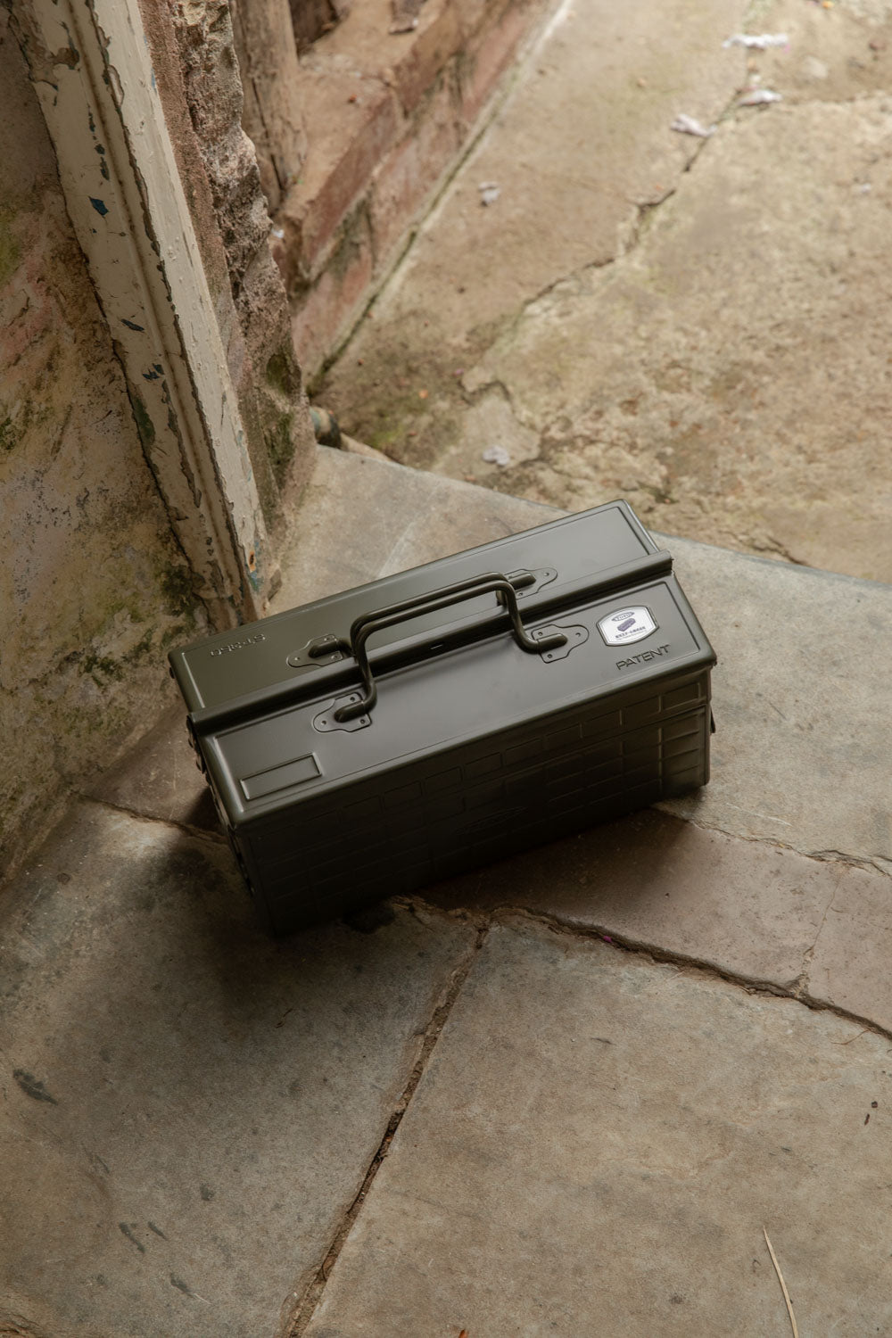 Olive green Toyo cantilever toolbox on worn flagstones