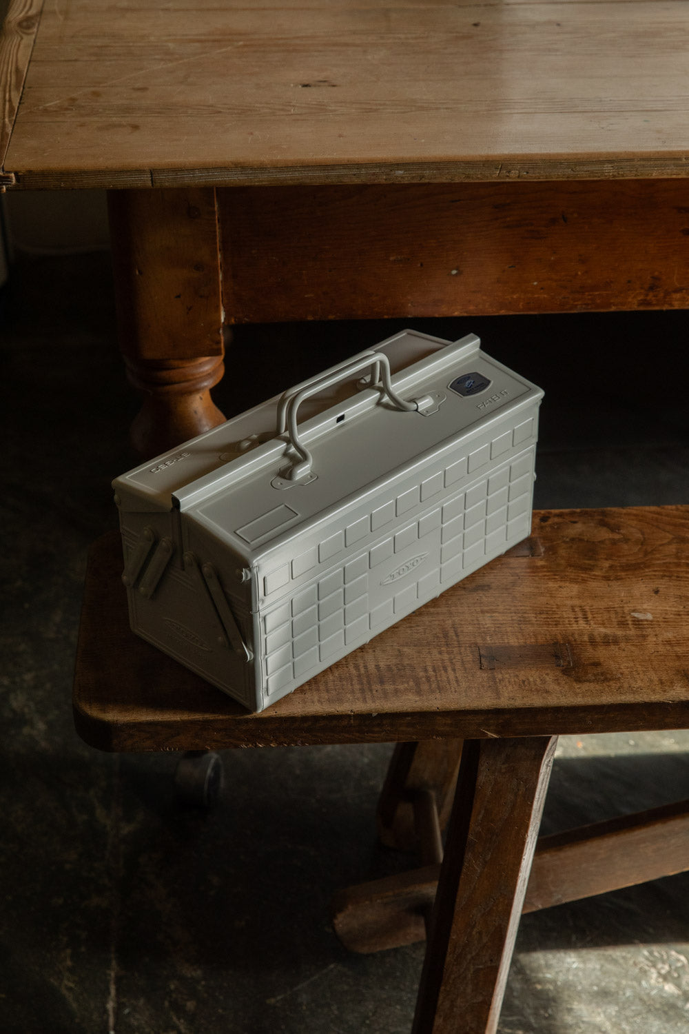Silver steel Toyo cantilever toolbox with handle on a wooden bench