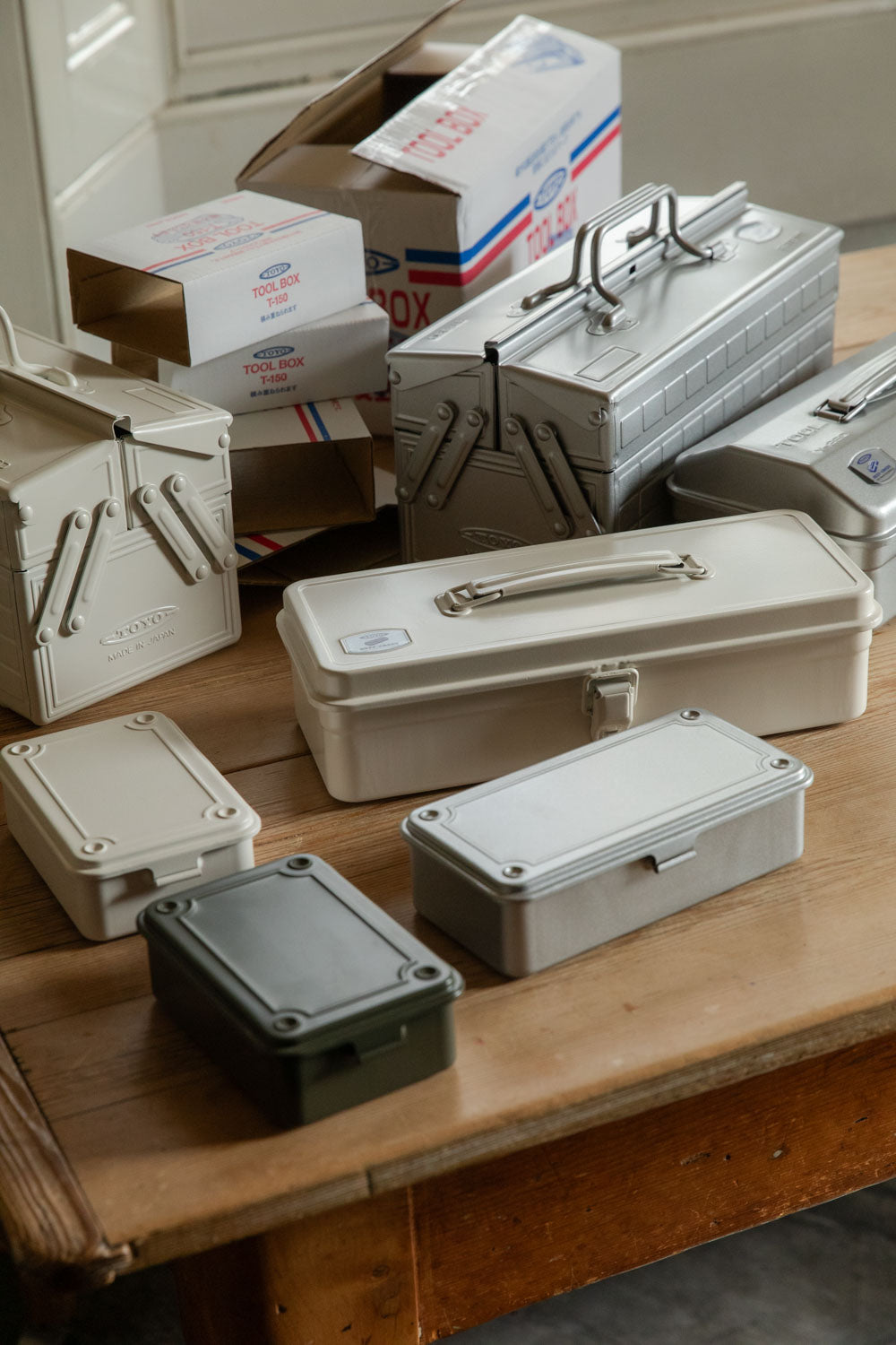 Collection of Toyo steel toolboxes in white, grey and olive with retro packaging