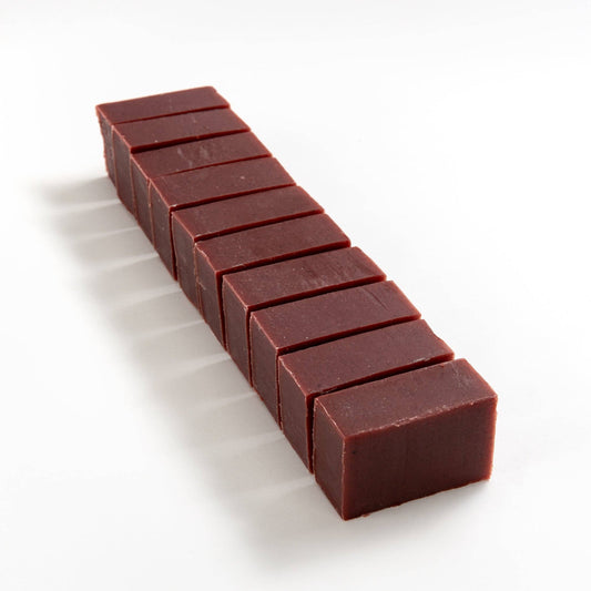 Block of vintage rose soap brick cut into smaller pieces on a white background.