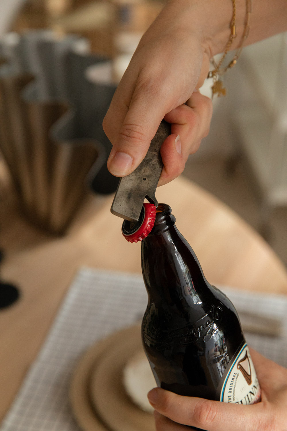 Close-up of a whale bottle opener lifting a bottle cap