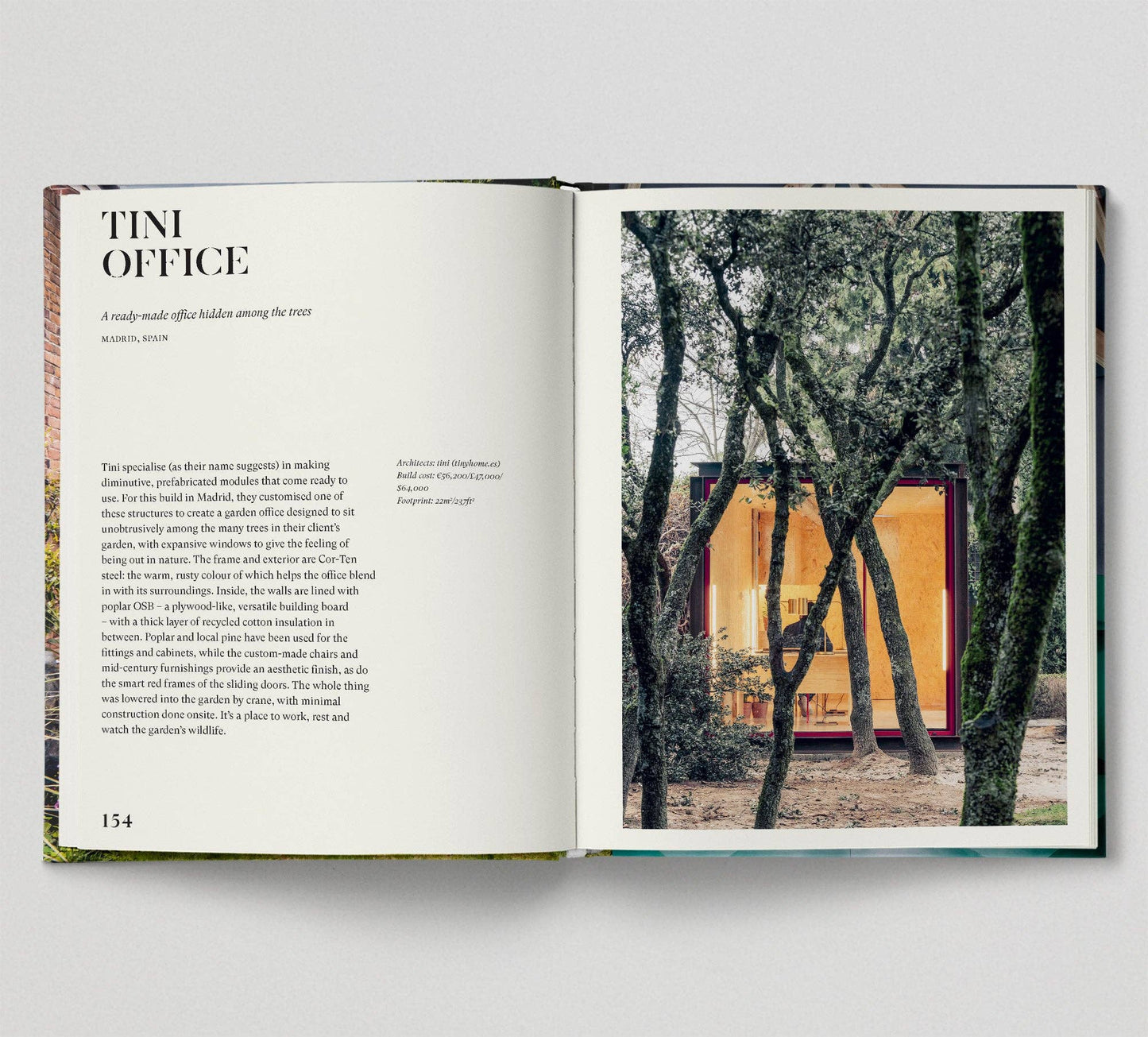 Open book showing a page with text and an image of a small office building in a forest.