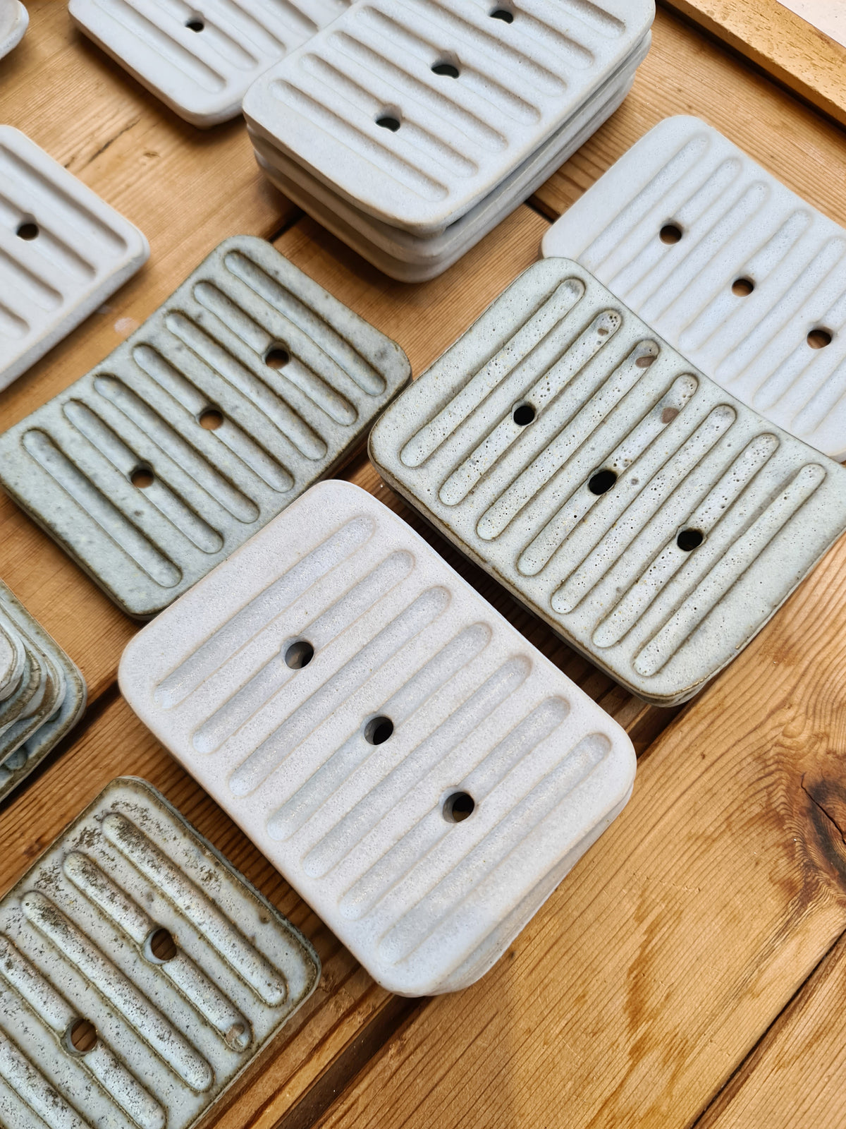 Large white ridged ceramic soap dish among other handmade dishes
