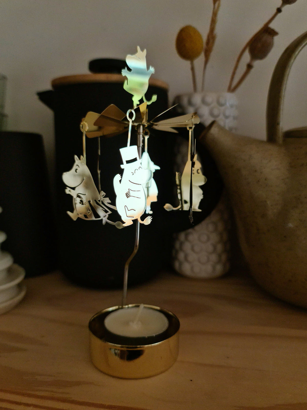 Moomin Änglaspel set against dark stoneware jugs