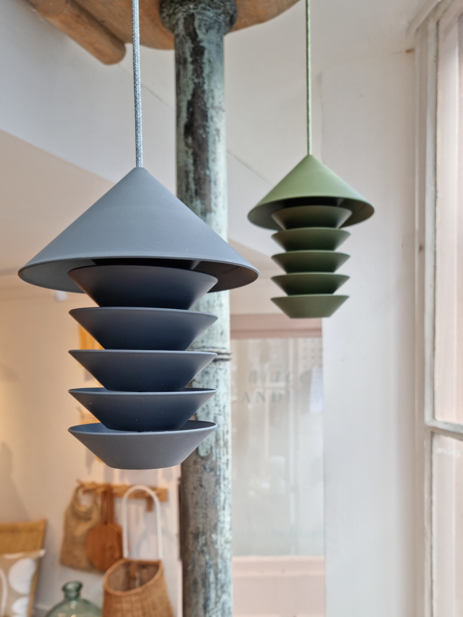 Pidät Bird Silo Feeder in slate and camp green hanging together in shop interior