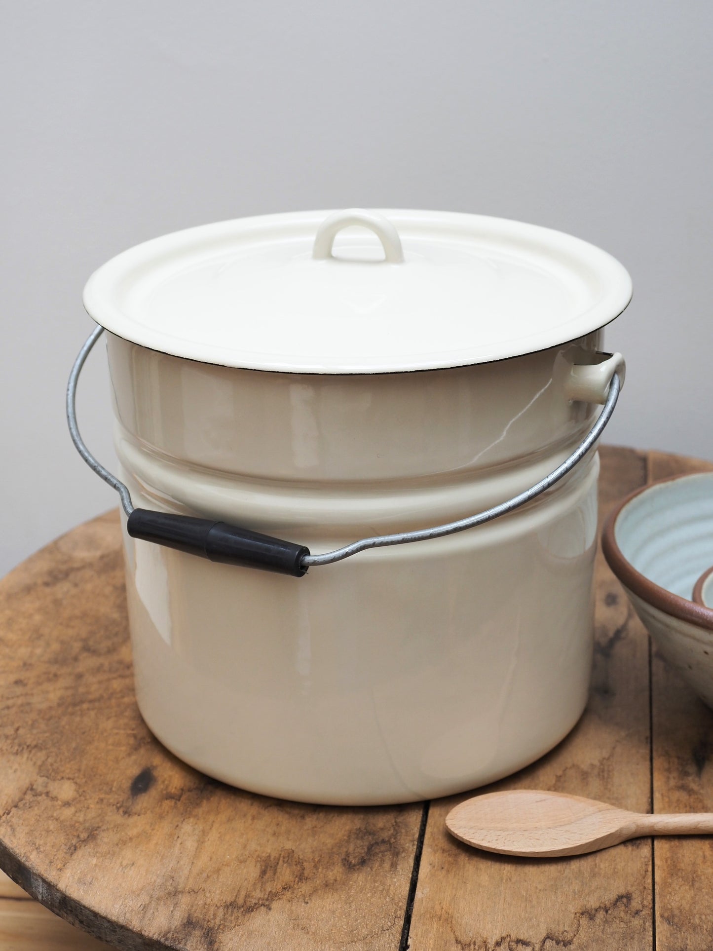 Strömshaga Emil's enamel bucket 12L with lid and handle standing on wooden table