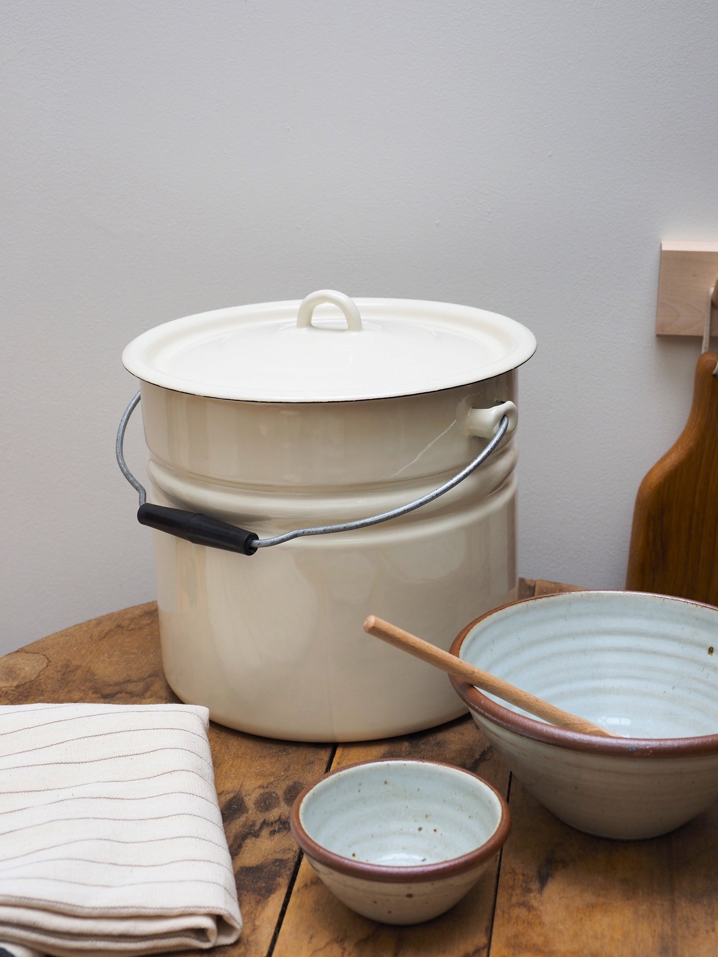 Strömshaga Emil's white enamel lidded bucket 12L styled with ceramic bowls on wooden table