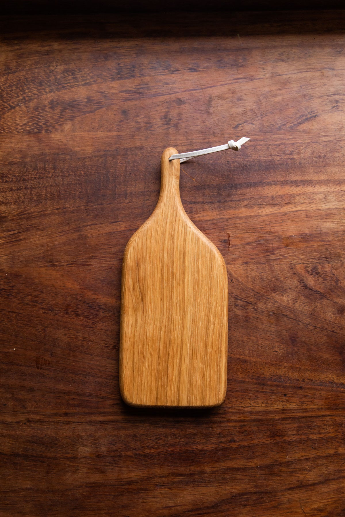 An English Oak mini board is laid on a dark brown wooden tabletop. Taken from a birds eye view.