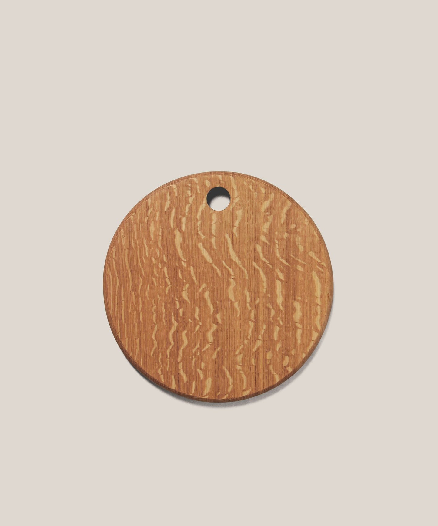 A round, English oak wood board with a hole at the top, placed on a white background.