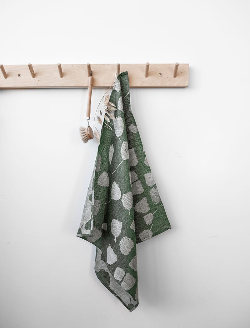 Fine Little Day's green bouquet tea towel hanging from a peg rail.