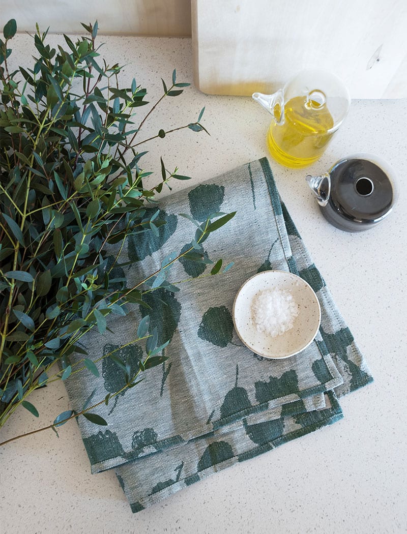 Fine Little Day's green bouquet tea towel placed on a kitchen counter.