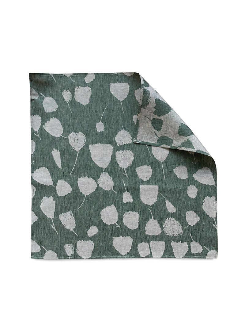Fine Little Day's green bouquet tea towel laying flat with one corner flipped over to show the reverse side.