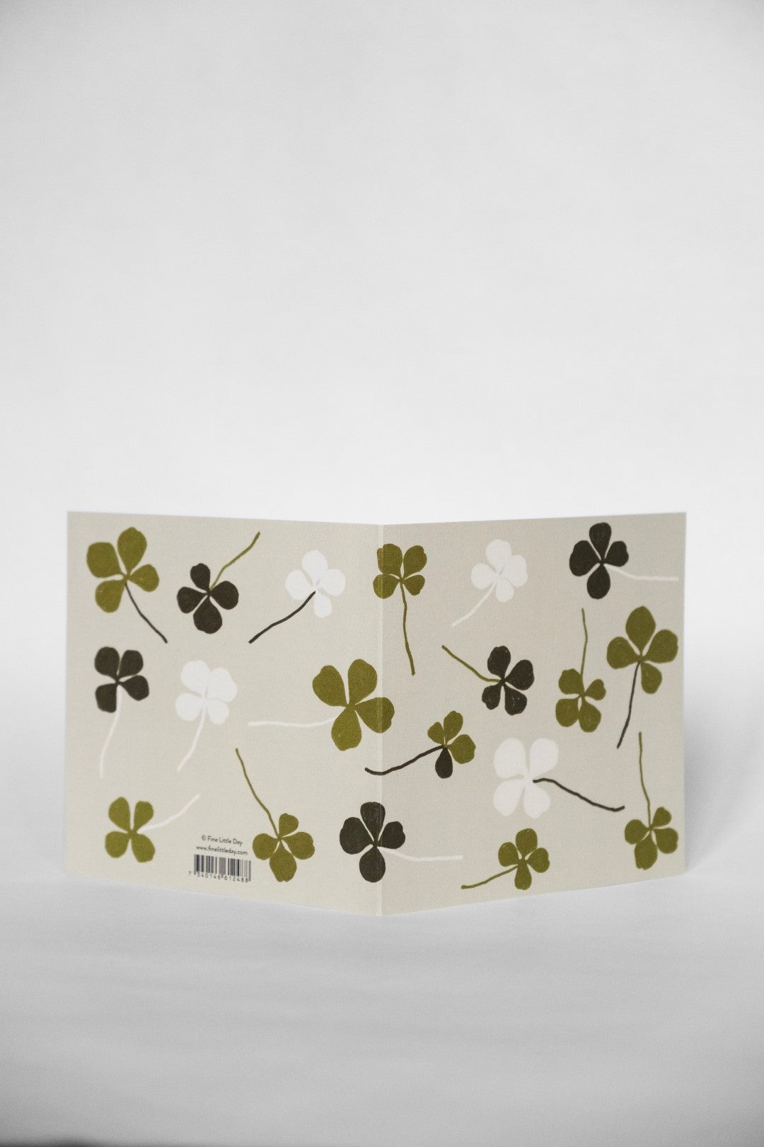 A greeting card with a four leaf clover design and green accents on a white background.
