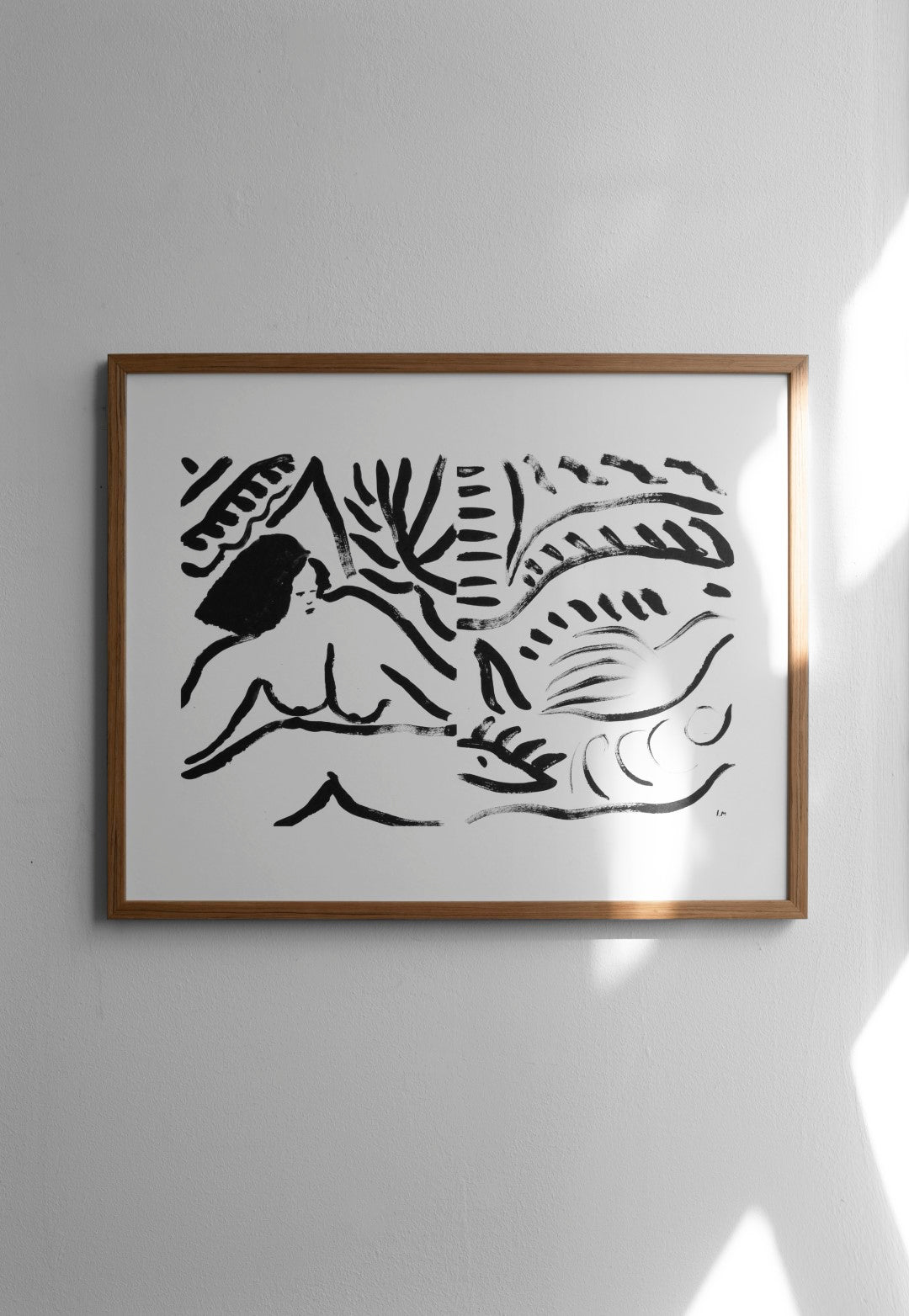 A framed poster featuring a black and white abstract artwork, hanging on a white wall.