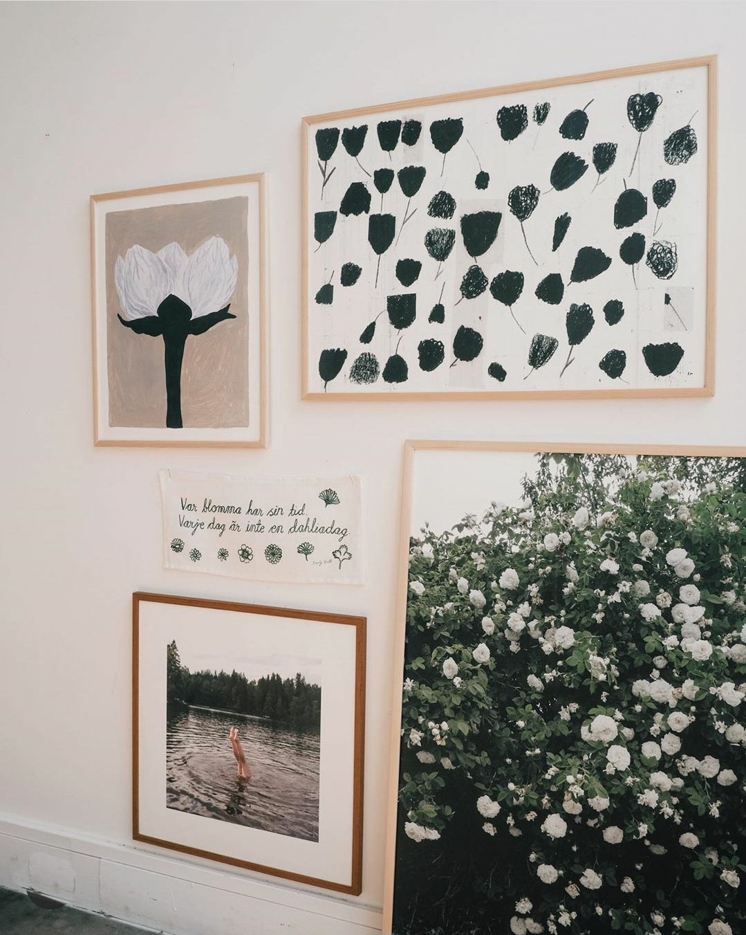 Gathering of framed prints on a white wall.