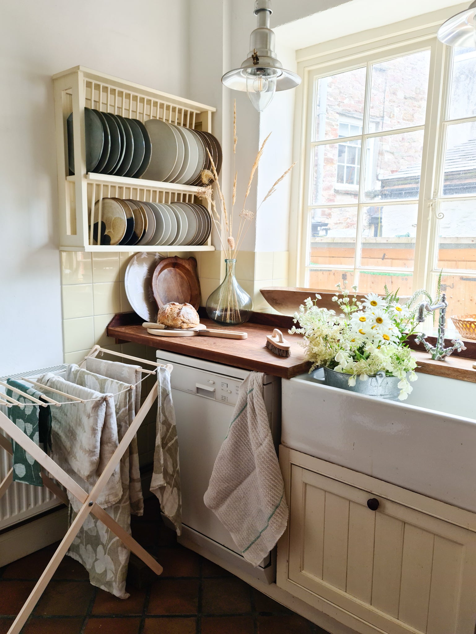 Foldable wooden wash drier airer with clothes drying on it, placed in a kitchen.