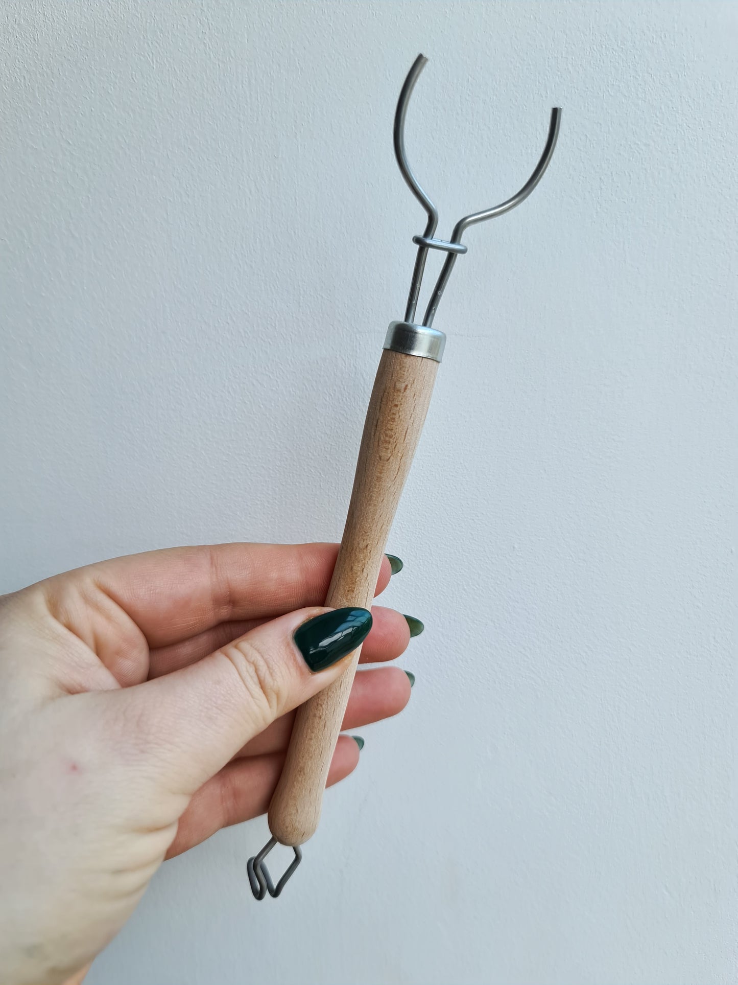 A hand holding a dish brush without the replaceable head attachment.  