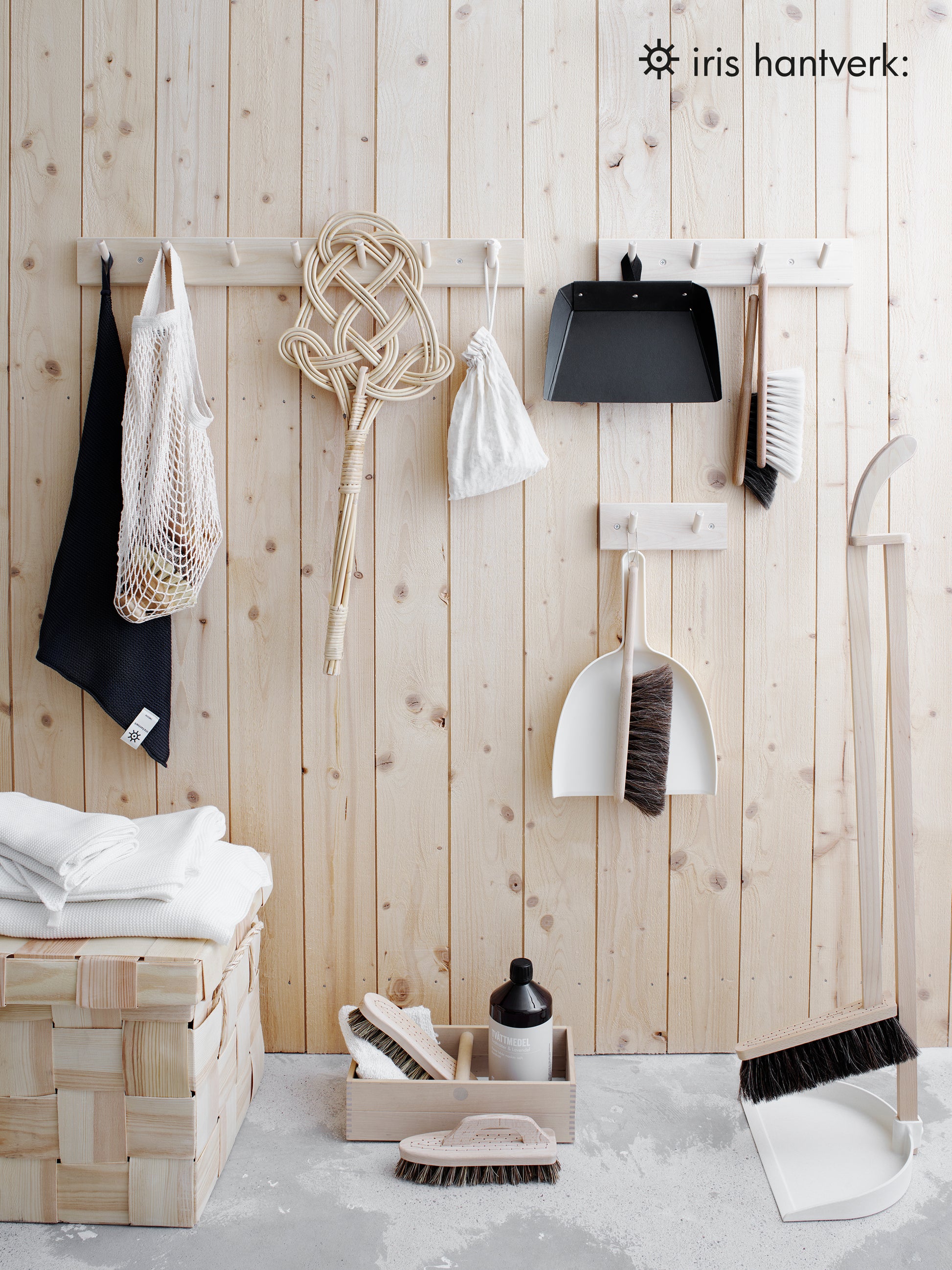 A peg rail rack made of birch wood with multiple hooks, mounted on a wall and holding various items and tools.