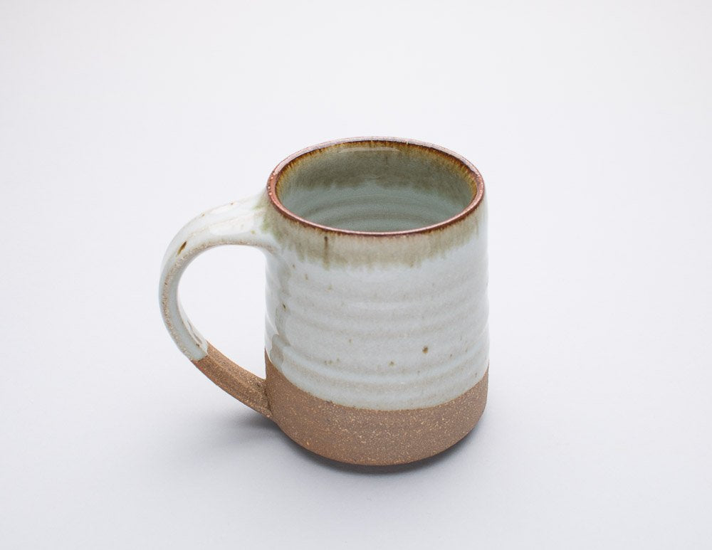 A Leach Pottery stoneware mug shown against a white background.