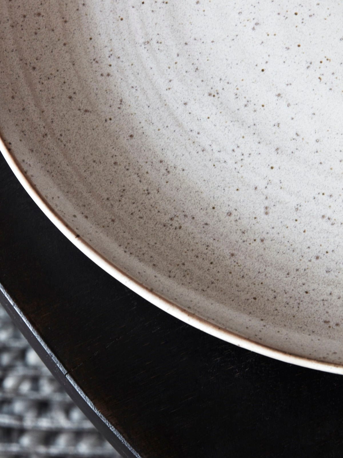 Close up of a speckled white dinner plate.