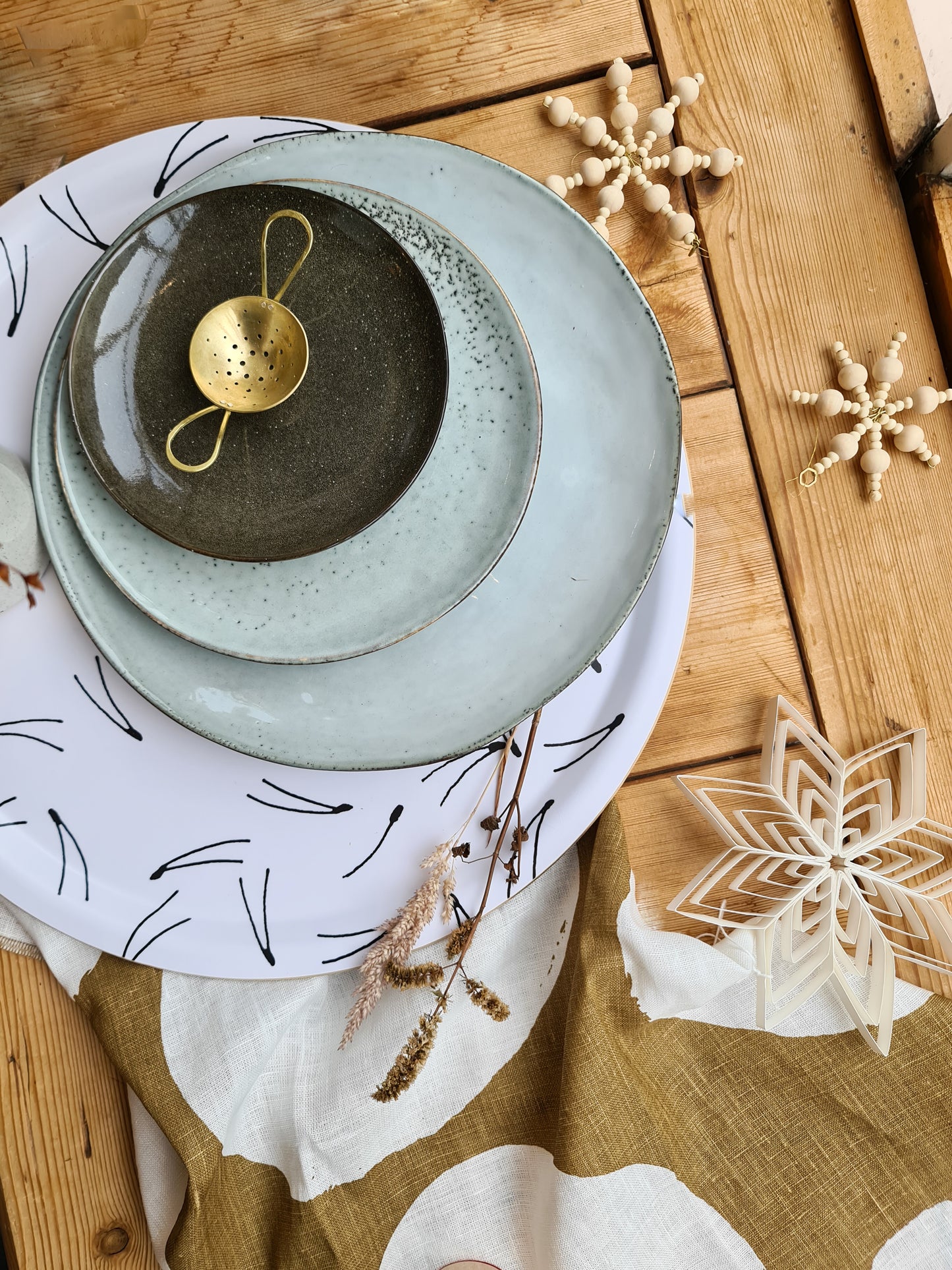 Table setting showing a rustic dinner plate and cake plate on top of a tray, with other objects scattered around.
